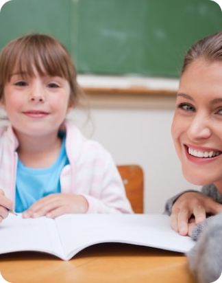 A student and teacher smiling with a book open