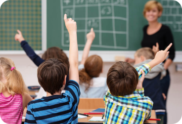 Students raising hands to answer teacher's question